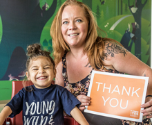 Mother and boy patient holding Thank You sign