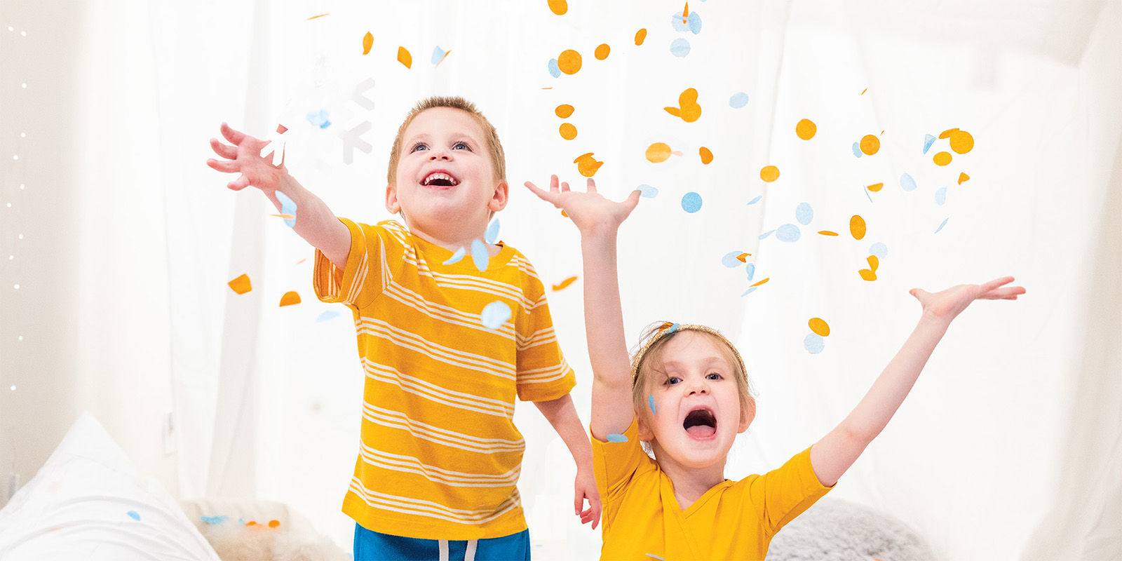Two children throwing confetti