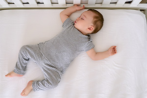 a baby laying on their back in a bare crib