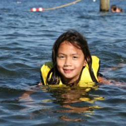 A girl in a lifejacket swimming