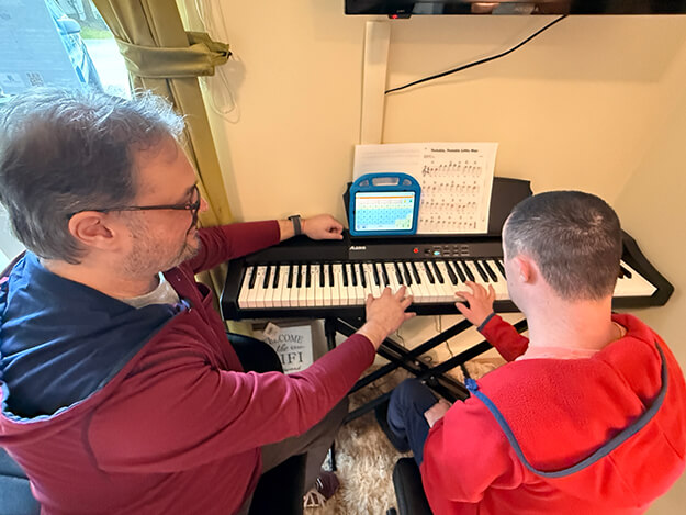 Music therapist and client at keyboard