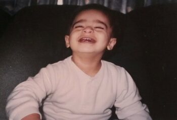 A young boy smiles at the camera