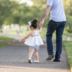 A girl walks with her father