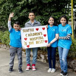 Four children hold a sign that reads "Seattle Children's Hospital is the best!"