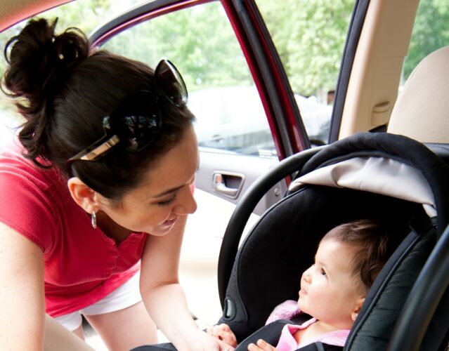 Parent smiles at child in car seat