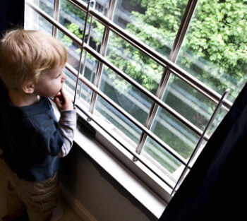 toddler stands by window