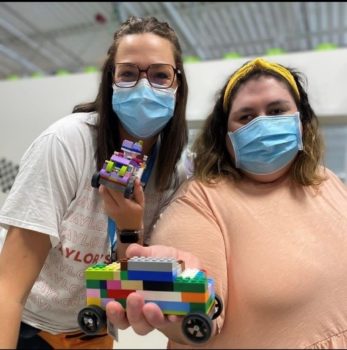 Two women show off Lego cars they made