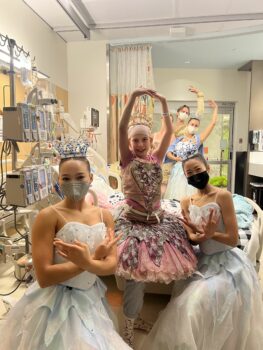 A patient wearing the most beautiful tutu is surrounded by ballerinas
