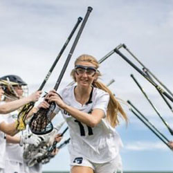 A team of female college lacrosse players on the field
