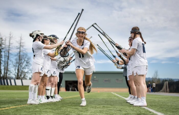 A team of female college lacrosse players on the field