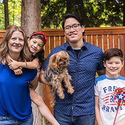 a family poses for a photo in their back yard