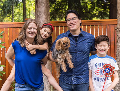a family poses for a photo in their back yard