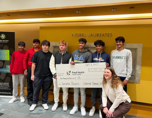 A group of students pose with an oversized check inside Seattle Children's Hospital
