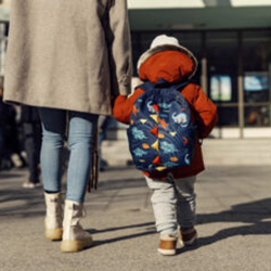 A girl walks with her parent to school