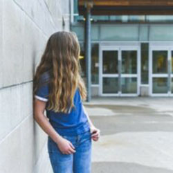 A girl stands outside a school