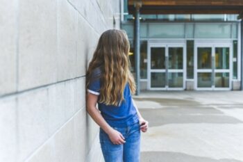 A girl stands outside a school
