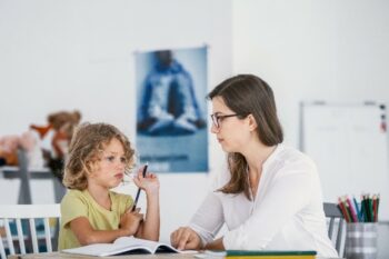 a child works on homework while an adult supervises