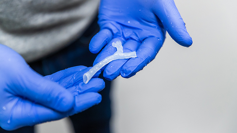 Custom 3D printed airway piece being held in gloved hands
