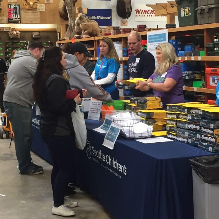 Seattle Children's volunteers give away free gun lockers to the public.