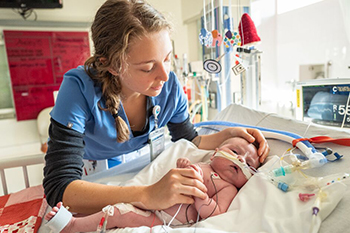 Neonatal physicians assistant examines a baby in the NICU.
