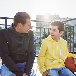 Father and son chatting while sitting outside