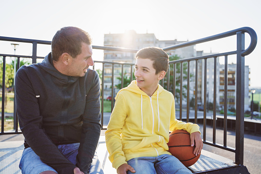 Father and son chatting while sitting outside