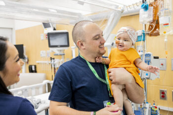 A father holds his daughter in a hospital