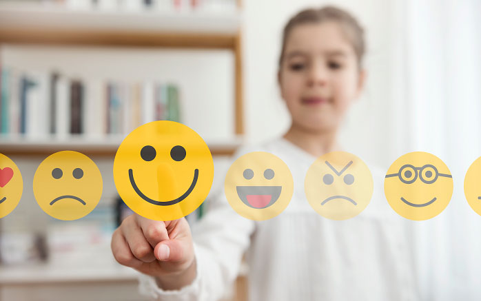 A child chooses their mood by pointing at an emoji.