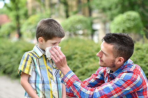 Father holding cloth over son's mouth and nose to help filter wildfire smoke