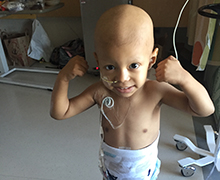 Tiago flexing his arms to show how strong he is against cancer.