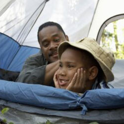 A boy and his father in a tent