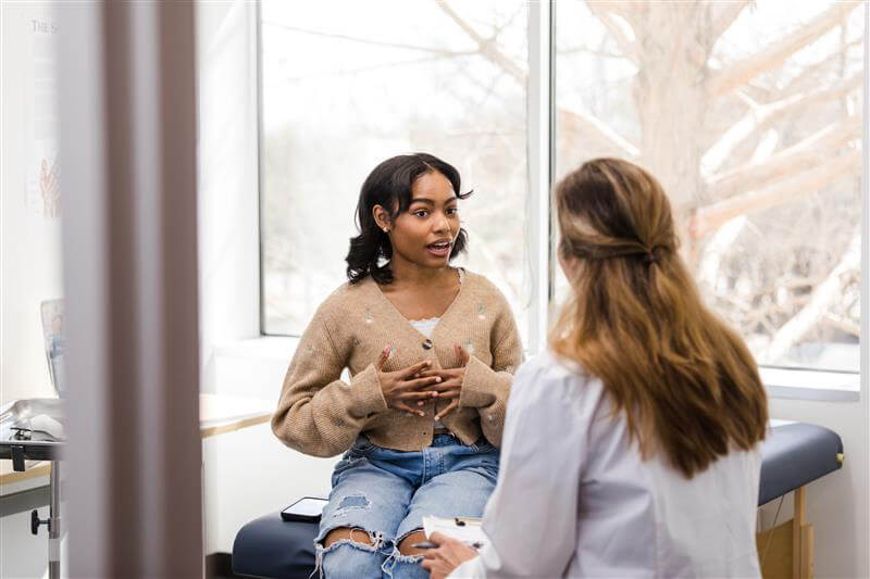 A supportive face-to-face consultation between a patient and provider in a bright, comfortable clinic setting, illustrating the clinic's focus on trust and connection.