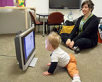 A baby looks at a screen