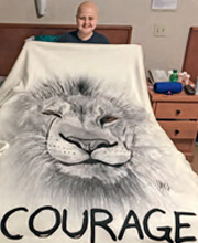 A child holding a blanket that reads "courage"