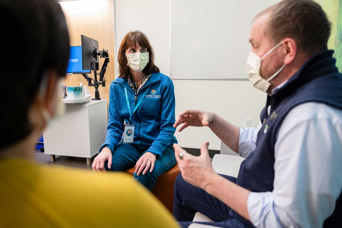 Providers in an exam room discuss a patient