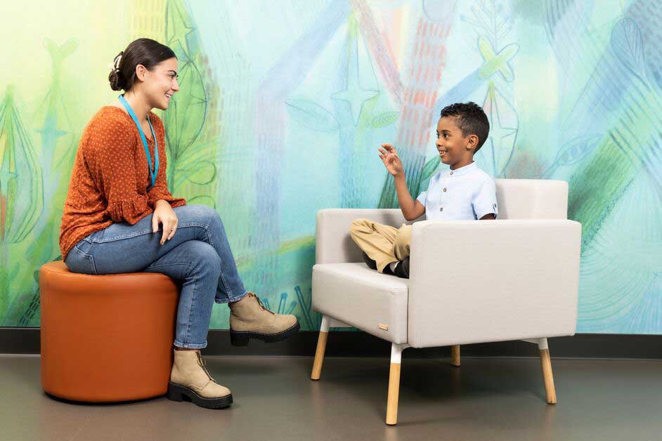 A boy speaks with a provider in a treatment room