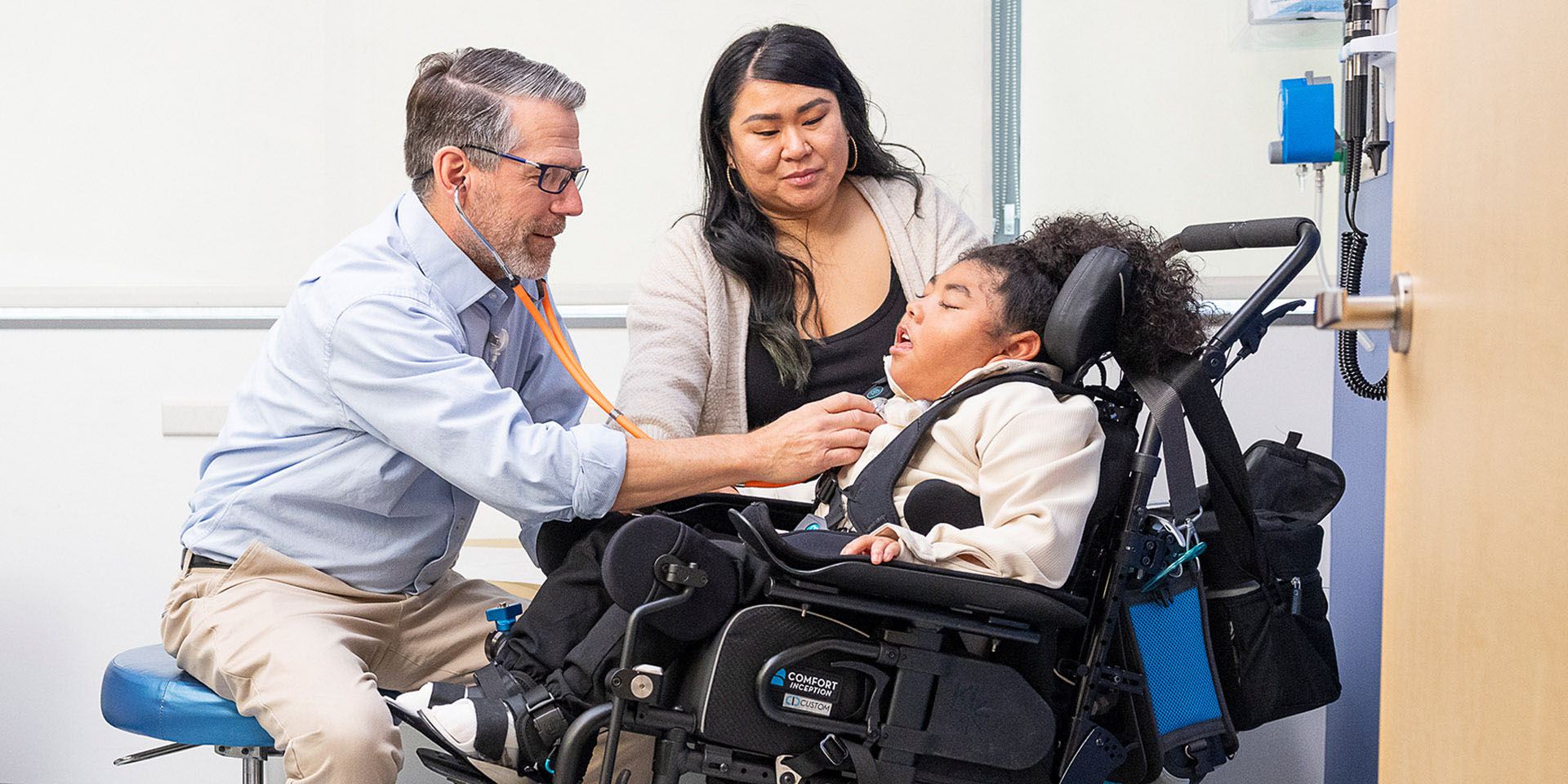 A doctor examining a patient as the mother looks on