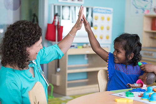 A young patient high-fives a provider at Seattle Children's.