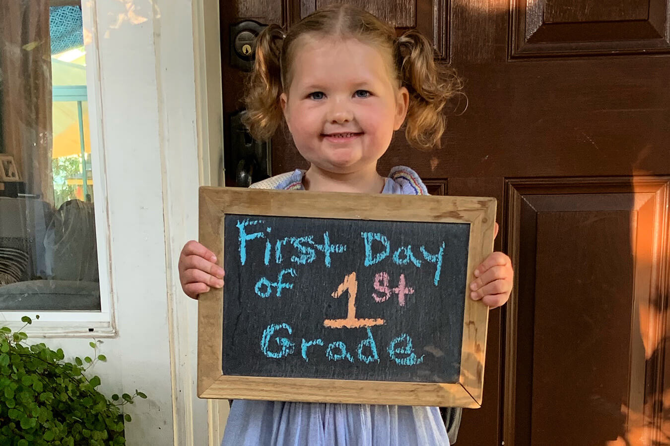 Greta holding First Day of 1st Grade sign