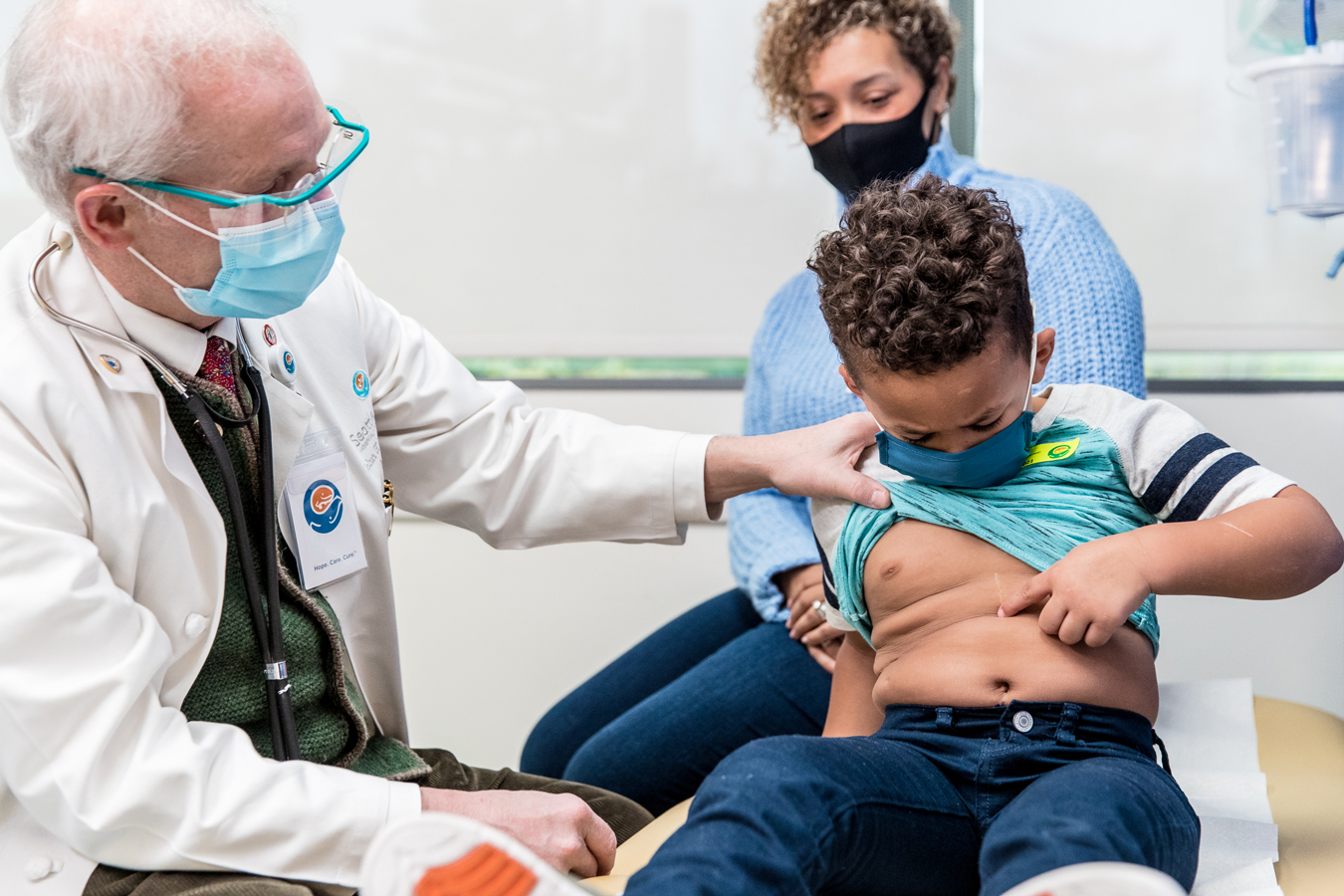 Dr. Waldhausen in mask with patient examining surgical scar