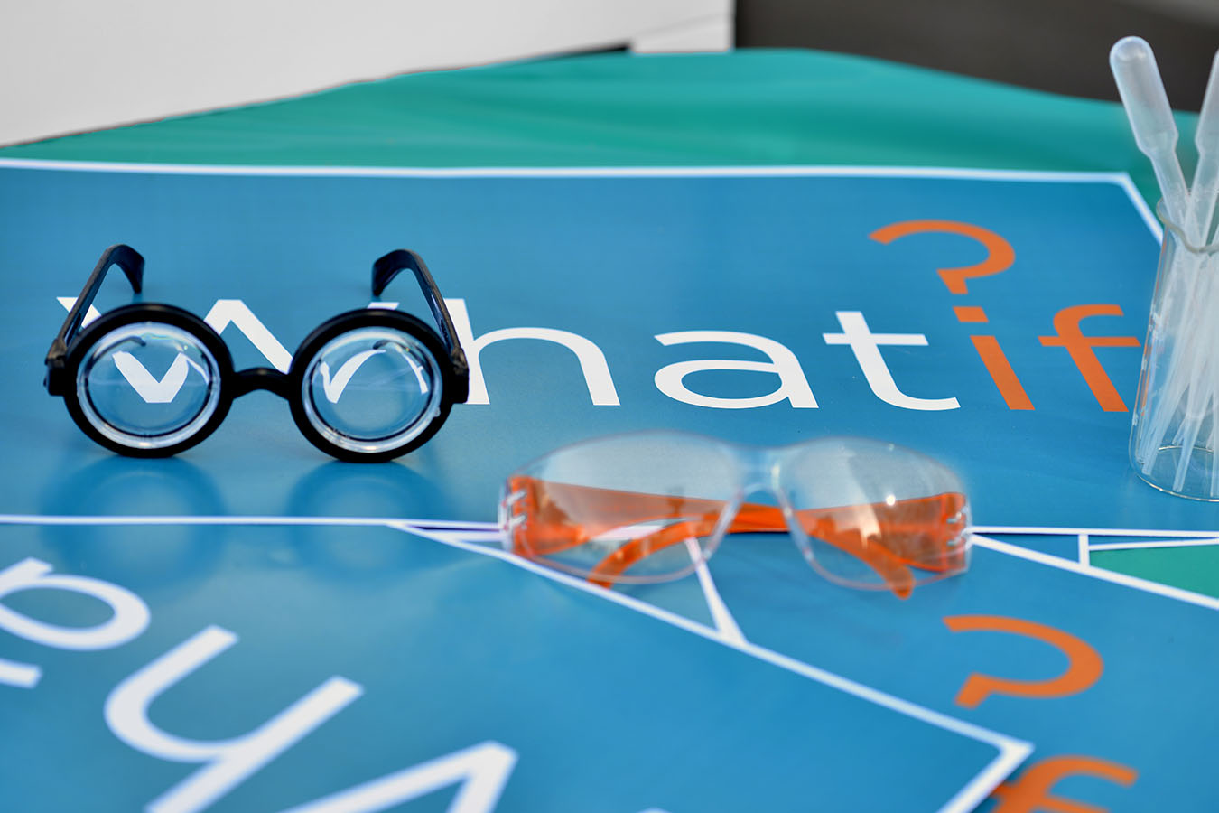 Glasses sit atop a "what If" sign.