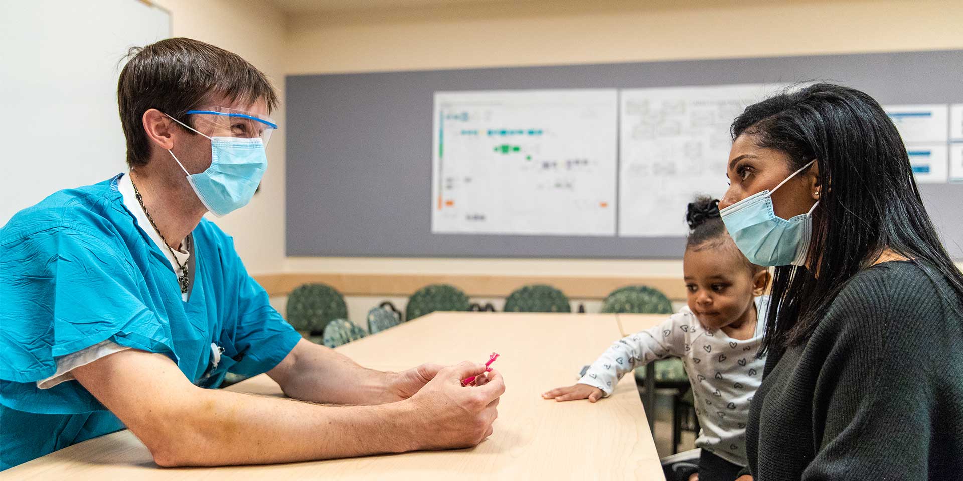 Dr Johnson of the Airway and Esophageal Center consulting with a mother holding a small child.