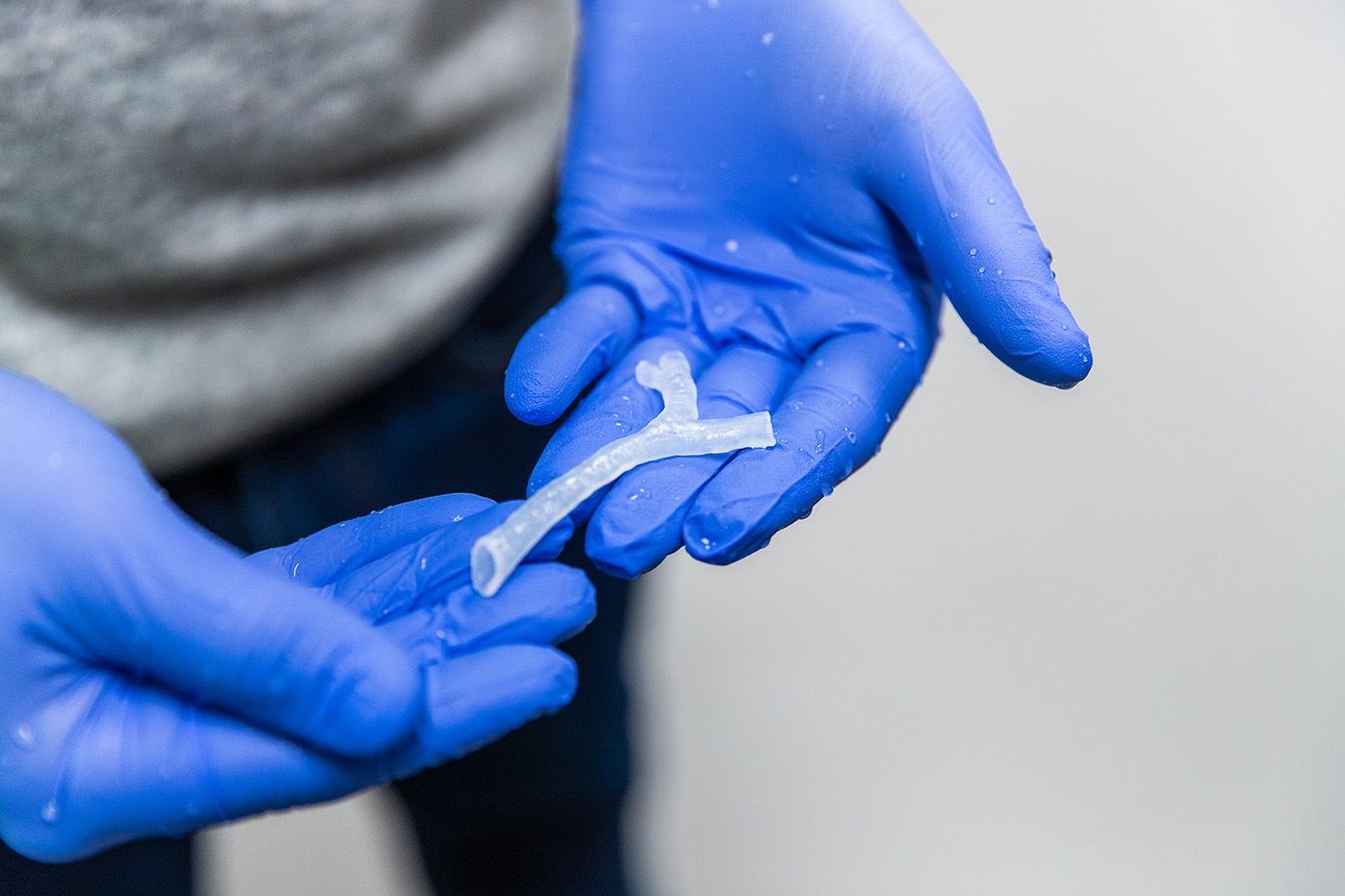 Gloved hands holding a 3-d printed airway
