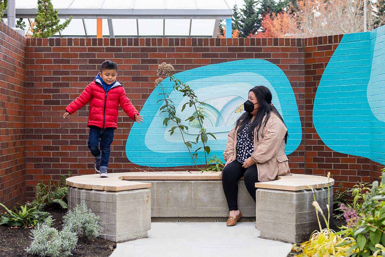 A boy in a red jacket explores the Sensory Garden at Seattle Children's Magnuson