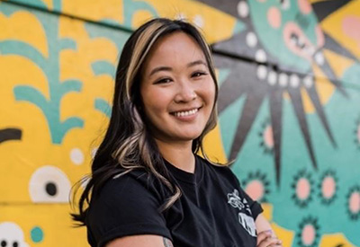 Stevie Shao poses in front a mural