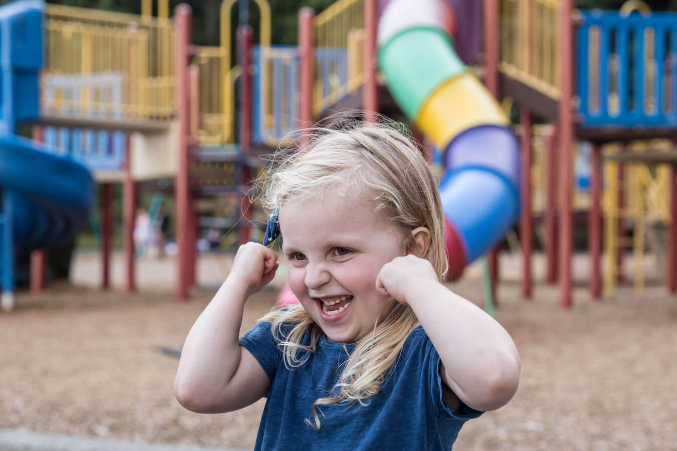 An excited young girl at an outdoor playground