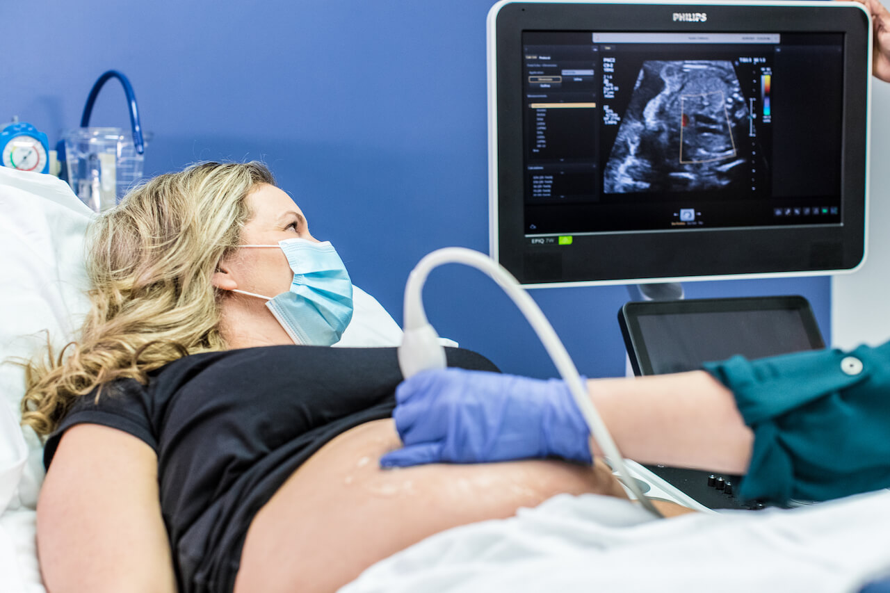 Pregnant woman looking at her baby on ultrasound screen