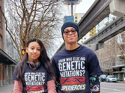 Two teens stand outside in Seattle with the Space Needle in the background