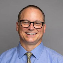 A male doctor smiling at the camera
