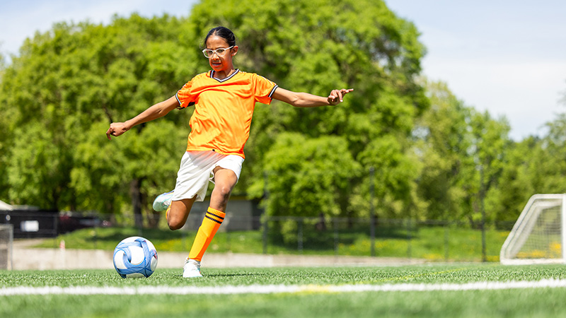 A girl kicking a soccer ball